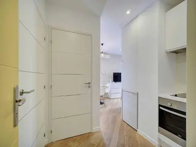 a kitchen with white cabinets and a door in a room at Lovely renovated apart Terrace - Mobility lease in Cannes