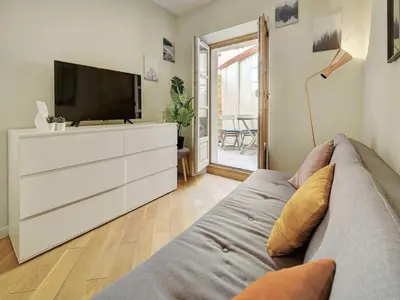 a living room with a couch and a flat screen tv at Lovely renovated apart Terrace - Mobility lease in Cannes