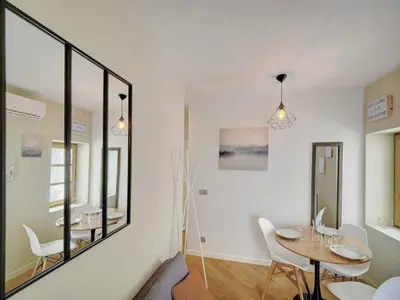 a dining room with a table and a mirror at Lovely renovated apart Terrace - Mobility lease in Cannes