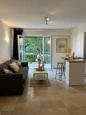 a living room with a couch and a table at Coquet studio 10 min de Cannes in Le Cannet