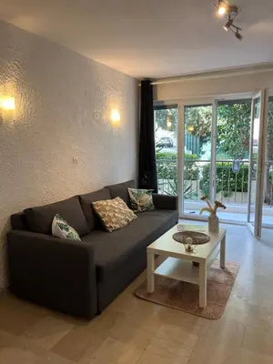 a living room with a couch and a table at Coquet studio 10 min de Cannes in Le Cannet