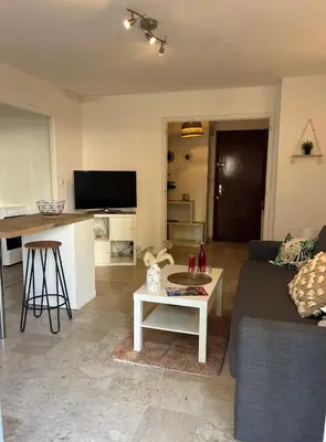 a living room with a couch and a table at Coquet studio 10 min de Cannes in Le Cannet