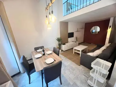 a dining room and living room with a table and chairs at Studio Design et Cosy à 8 min à Pied des Plages in Cannes