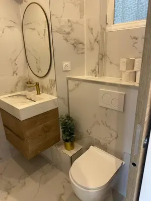 a bathroom with a toilet and a sink and a mirror at Suite le Venitia - Appartement standing in Cannes