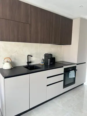 a kitchen with white cabinets and a sink at Suite le Venitia - Appartement standing in Cannes