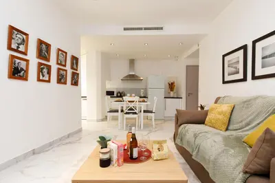 a living room with a couch and a table at Le Napoléon, 1min Palais des Festivals in Cannes