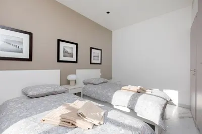 two beds in a bedroom with white walls at Le Napoléon, 1min Palais des Festivals in Cannes