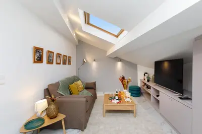 a living room with a couch and a tv at Le Napoléon, 1min Palais des Festivals in Cannes