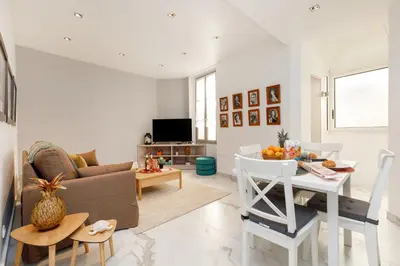 a living room with a couch and a table at Le Napoléon, 1min Palais des Festivals in Cannes