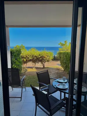 a patio with a table and chairs and a view of the ocean at Superbe appartement in Cannes