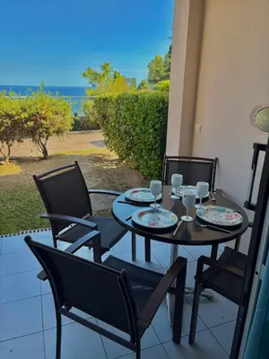 a table and chairs on a patio with a view of the ocean at Superbe appartement in Cannes