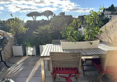 a wooden table and chairs on a balcony with plants at Charming apartment in Cannes in Cannes