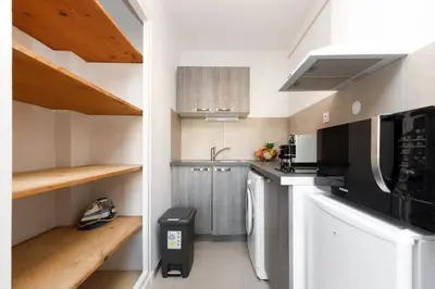 a kitchen with stainless steel appliances and wooden ceilings at Le Lido YourHostHelper in Cannes