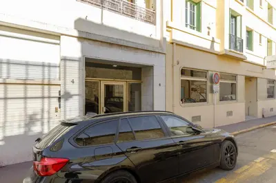 a black car parked in front of a building at Le Lido YourHostHelper in Cannes