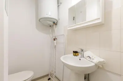 a white bathroom with a sink and a toilet at Le Lido YourHostHelper in Cannes