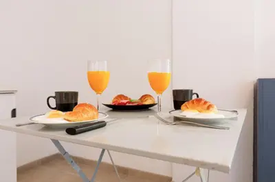 two glasses of orange juice and croissants on a table at Le Lido YourHostHelper in Cannes