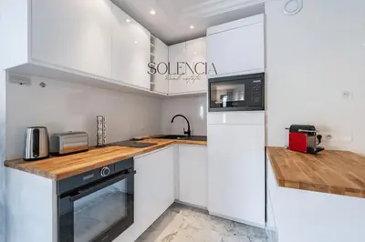 a white kitchen with a sink and a refrigerator at 2 pièces rue d'Antibes - Climatisation in Cannes