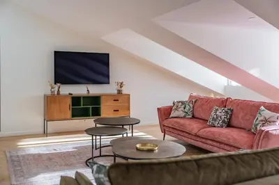 a living room with a red couch and a tv at 4 pièces sur la rue d'Antibes - Rénové et climatisé in Cannes