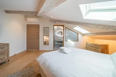 a bedroom with a large white bed and a skylight at 4 pièces sur la rue d'Antibes - Rénové et climatisé in Cannes