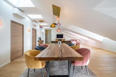 a dining room with a wooden table and chairs at 4 pièces sur la rue d'Antibes - Rénové et climatisé in Cannes