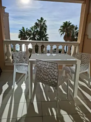 a white table and chairs on a balcony with the ocean at Cap ô sud 1 in Cannes