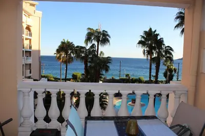 a balcony with a view of the ocean and palm trees at Cap ô sud 1 in Cannes