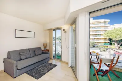 a living room with a couch and a table at Colline Azur YourHostHelper in Cannes