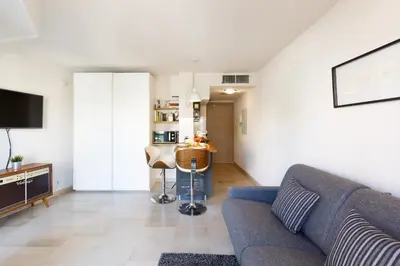a living room with a couch and a table at Colline Azur YourHostHelper in Cannes