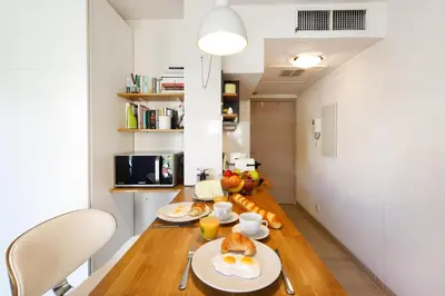 a kitchen with a table with plates of food on it at Colline Azur YourHostHelper in Cannes