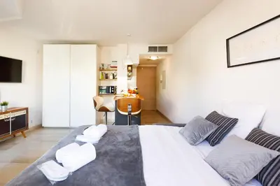 a bedroom with a large bed and a living room at Colline Azur YourHostHelper in Cannes