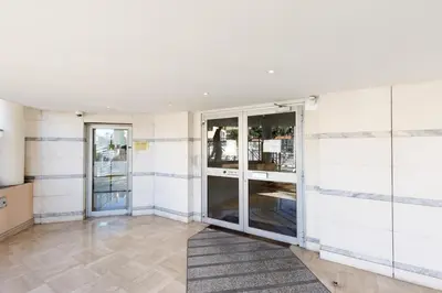 a room with white tiled walls and glass doors at Colline Azur YourHostHelper in Cannes