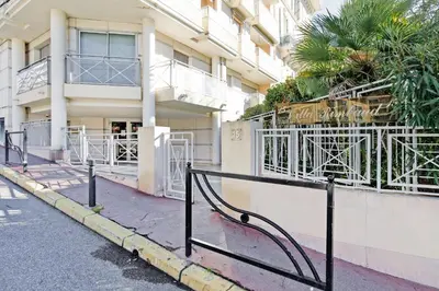a building with a gate in front of a street at Colline Azur YourHostHelper in Cannes