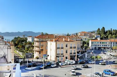 a city with cars parked in a parking lot at Colline Azur YourHostHelper in Cannes