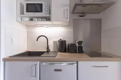 a kitchen with a sink and a microwave at L'AZUR avec terrasse vue mer, piscine accessible et près des plages in Cannes