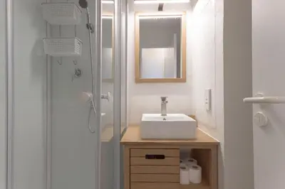 a bathroom with a sink and a shower with a mirror at L'AZUR avec terrasse vue mer, piscine accessible et près des plages in Cannes