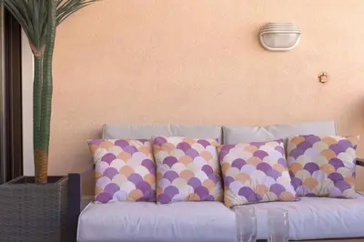 a blue couch with polka dot pillows on it at L'AZUR avec terrasse vue mer, piscine accessible et près des plages in Cannes