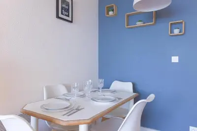a table with plates and wine glasses on it at L'AZUR avec terrasse vue mer, piscine accessible et près des plages in Cannes