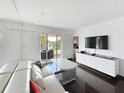 a white living room with a white couch and a table at One bedroom apartment on La Croisette - Sea view in Cannes