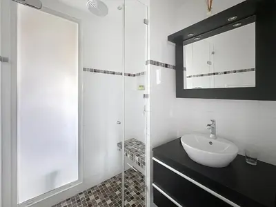 a white bathroom with a sink and a mirror at One bedroom apartment on La Croisette - Sea view in Cannes