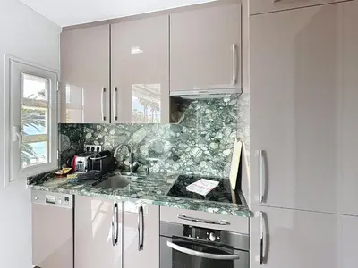 a kitchen with white cabinets and a sink at One bedroom apartment on La Croisette - Sea view in Cannes