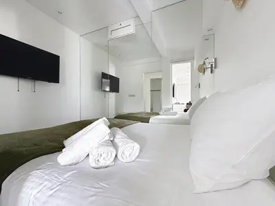a white bedroom with two white towels on a bed at One bedroom apartment on La Croisette - Sea view in Cannes