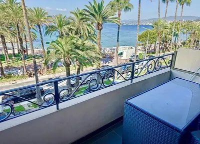 a balcony with a view of the ocean and palm trees at One bedroom apartment on La Croisette - Sea view in Cannes