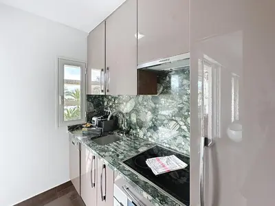 a white kitchen with a sink and a refrigerator at One bedroom apartment on La Croisette - Sea view in Cannes