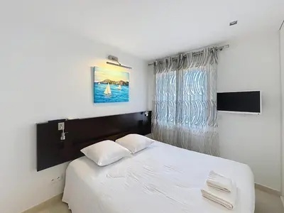 a bedroom with a white bed and a window at Modern 2-Bedroom Stunning Sea View on La Croisette in Cannes