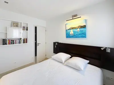 a bedroom with a large white bed with two pillows at Modern 2-Bedroom Stunning Sea View on La Croisette in Cannes