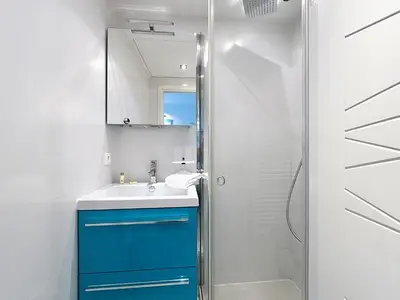 a bathroom with a blue cabinet and a shower at Modern 2-Bedroom Stunning Sea View on La Croisette in Cannes