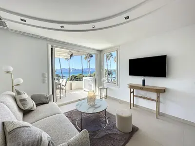 a living room with a couch and a tv at Modern 2-Bedroom Stunning Sea View on La Croisette in Cannes