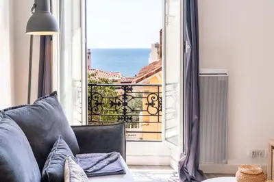 a living room with a couch and a view of the ocean at Le refuge du Suquet, quartier authentique de Cannes, vue mer in Cannes