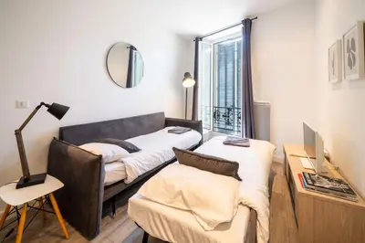 a living room with a couch and a chair at Le refuge du Suquet, quartier authentique de Cannes, vue mer in Cannes