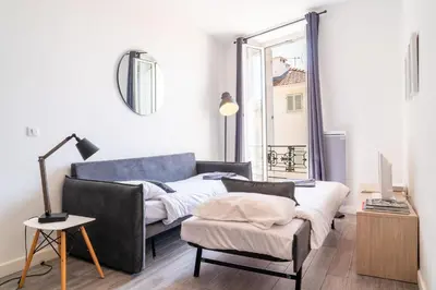 a living room with a couch and a chair and a window at Le refuge du Suquet, quartier authentique de Cannes, vue mer in Cannes